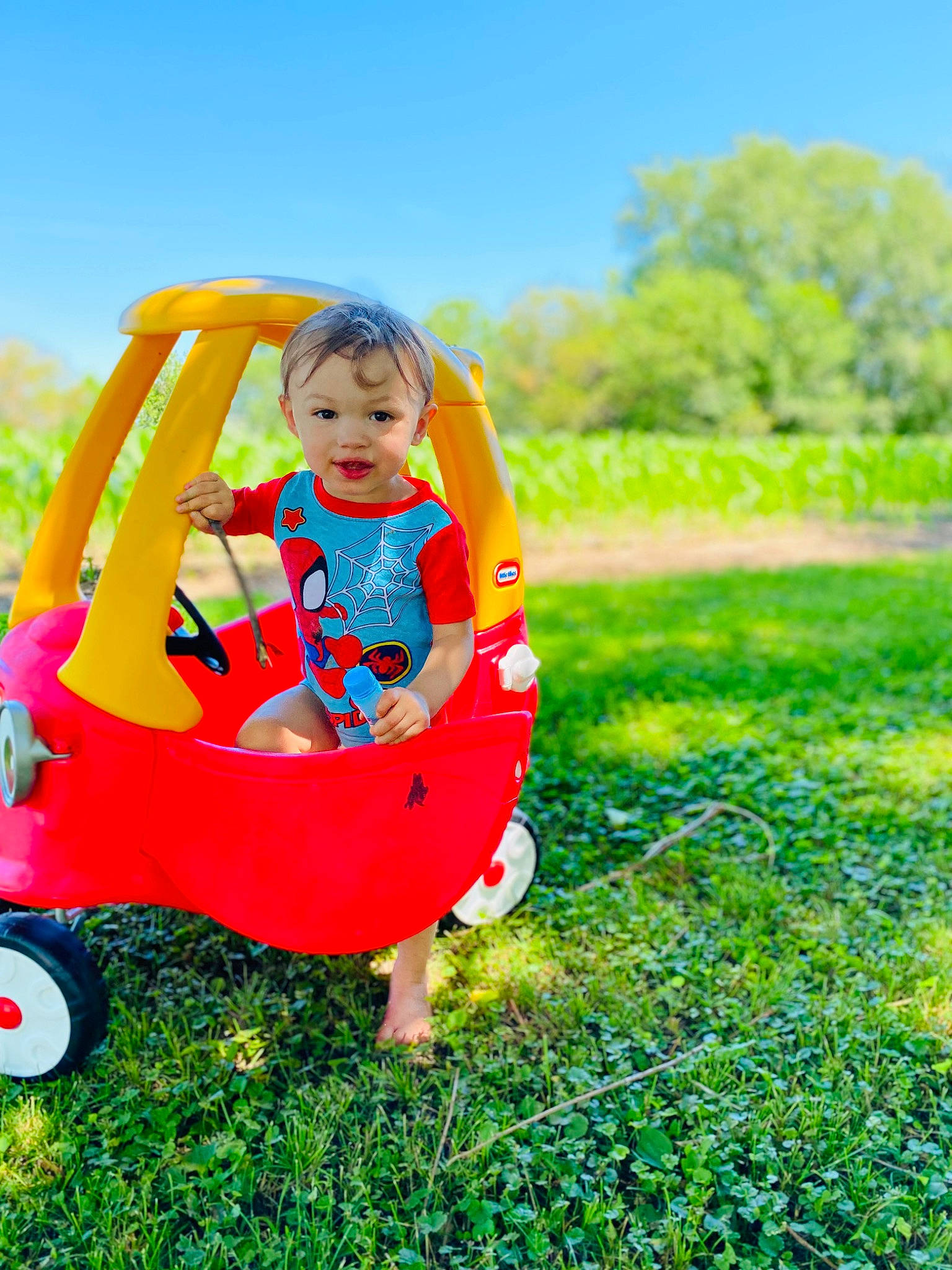 Jace is registered to the contest to win money with this photo: baby, baby_toddler_clothing, child, electric_blue, fun, grass, grassland, green, happy, landscape, lawn, leisure, people_in_nature, person, recreation, sitting, sky, tire, toddler, tree