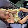 baby, car_seat, child, infant, yellow_clothing, sucking_hands, chubby_legs, purple_seat, car_interior, seat_belt, cute, adorable, relaxed, young_child, infant_girl, portrait, baby_pose, car_trip, child_safety, comfortable