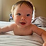 Elliana is registered to the contest to win money with this photo: baby, child, smiling, face, eyes, bed, blanket, skin, hair, indoors, expression, person, young, cute, infant, portrait, happy, lying_down, reaching, natural_light