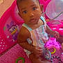Tyanna is registered to the contest to win money with this photo: baby, child, toy, playmat, pink, romper, indoor, plush, colorful, stuffed_animal, playpen, cartoon_character, floor, sitting, curious, infant, cute, person, young_child, room