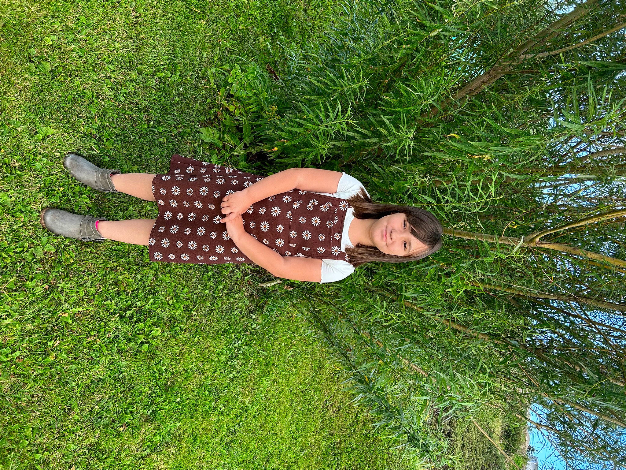 Gabriella is registered to the contest to win money with this photo: fun, garden, grass, grassland, groundcover, happy, human_leg, joy, knee, landscape, lawn, leisure, meadow, pattern, people_in_nature, person, plant, shrub, sky, sunglasses