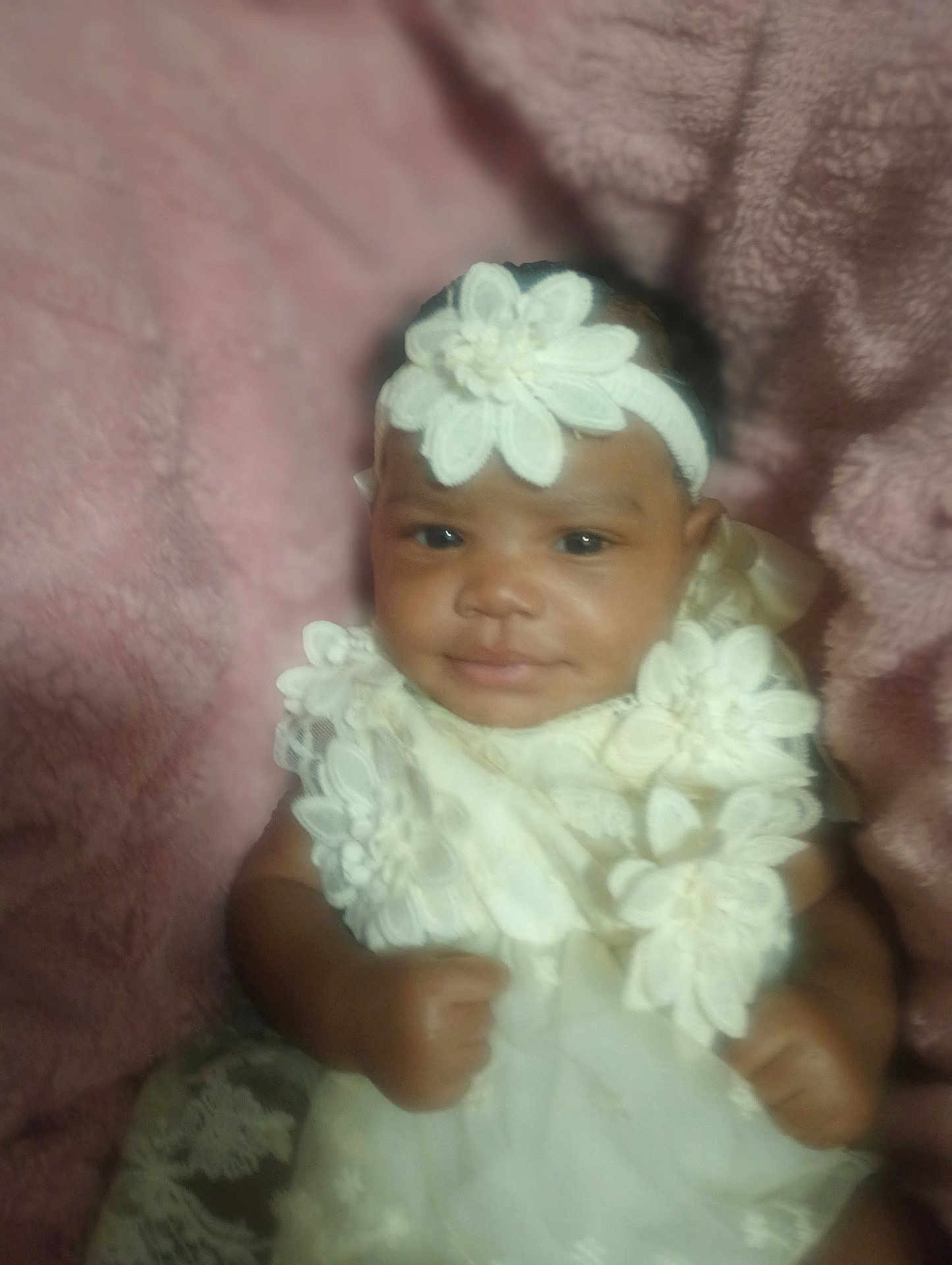 Ariana joined the competition — help win amazing prizes! baby, child, infant, white_dress, headband, flower, lace, pink_blanket, smile, portrait, cute, hands, soft_texture, indoors, young_child, happy, person, closeup, sitting, adorable