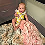 Lola joined the competition — help win amazing prizes! baby, child, infant, smiling, playpen, blanket, pink_blanket, patterned_blanket, lemon_pattern, sitting, happy, cute, indoors, mesh_sides, soft_texture, clothing, barefoot, young_child, portrait, play_area