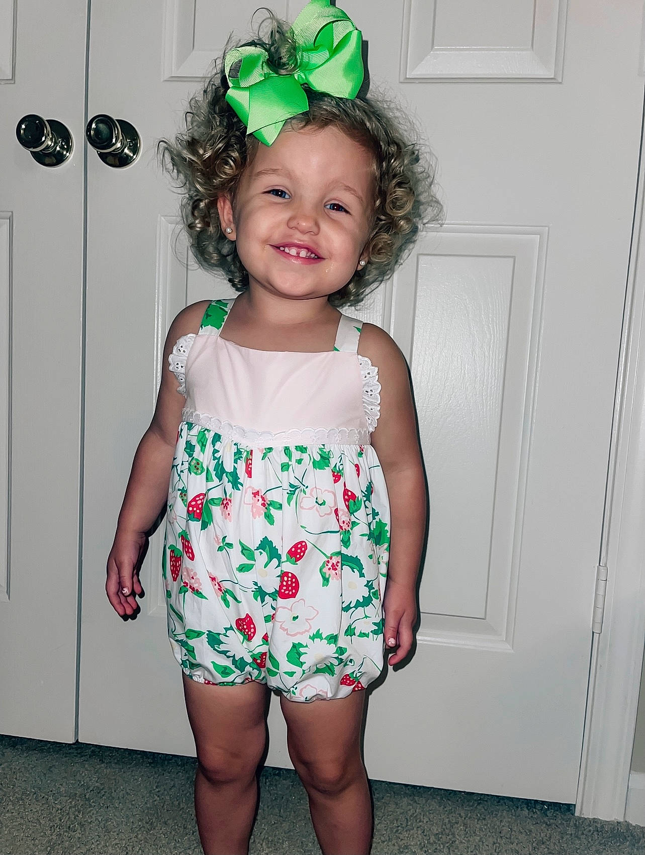 Sloane is registered to the contest to win money with this photo: arm, baby_toddler_clothing, clothing, costume_hat, day_dress, dress, face, green, happy, human_body, joy, magenta, pattern, person, pink, sleeve, smile, t_shirt, thigh, toddler