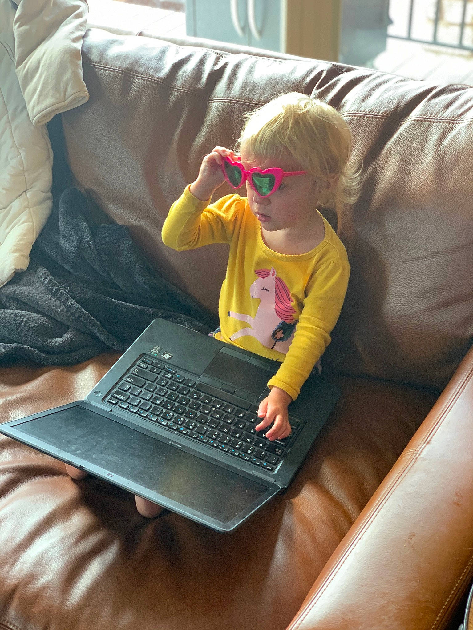 Natasha is registered to the contest to win money with this photo: comfort, computer, couch, fun, gadget, glasses, goggles, human_body, input_device, lap, laptop, leg, leisure, mammal, netbook, person, personal_computer, space_bar, textile, toddler