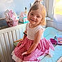 bench, bottle, brush, child, cushion, cute, dress, girl, hair_tie, happy, indoor, makeup, natural_light, pony_tail, portrait, red_checkered, sitting, skin_care, smile, window