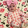 baby, infant, headband, bow, pink, floral_pattern, blanket, onesie, flower_print, laying_down, smiling, cheeks, wide_eyes, cute, portrait, fabric, shoe, decor, home_interior, soft_texture