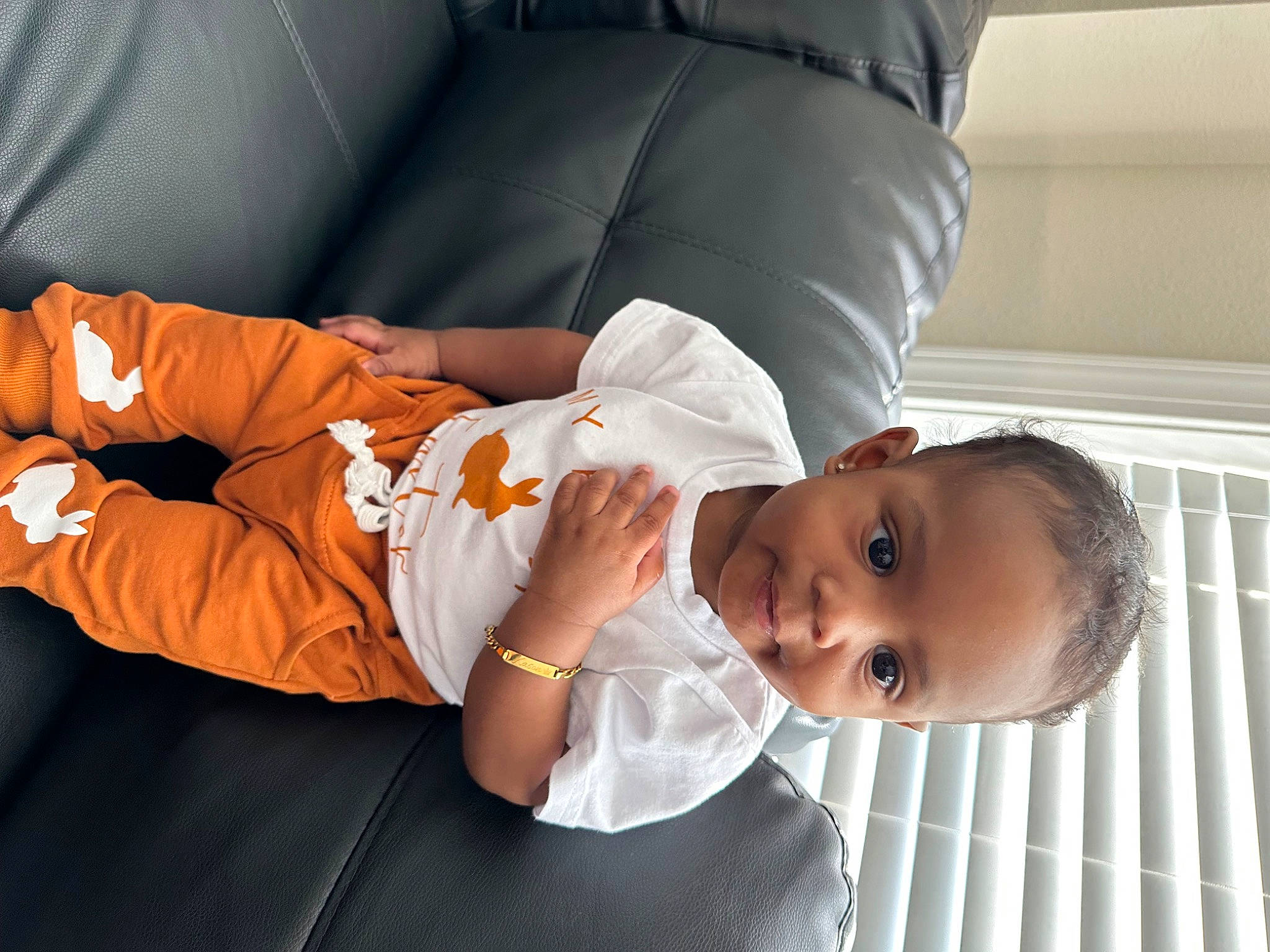 Kason is registered to the contest to win money with this photo: arm, baby, baby_products, baby_toddler_clothing, child, comfort, elbow, face, gesture, happy, human_body, human_leg, joint, mammal, mouth, person, room, sitting, sleeve, thigh