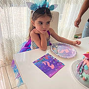 Eliza participe au concours pour gagner de l'argent avec cette photo : child, girl, mermaid_costume, headband, table, cake, plate, napkin, party, birthday, curtains, chair, fork, tulle, dress, indoor, floor, adult_arm, celebration, decor