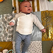 Keyan a rejoint le concours — aidez-le/la à gagner de superbes lots ! baby, infant, child, quilt, patchwork, toy, stuffed_animal, giraffe, green_toy, clothing, sweater, pants, socks, lying_down, indoor, cute, soft_toys, colorful, looking_away, floor_mat