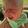 baby, infant, child, crying, sitting, car, car_interior, car_seat, green_outfit, onesie, socks, nike_socks, close_up, portrait, face, eyes_closed, open_mouth, sunlight, adult_hands, outdoor_background