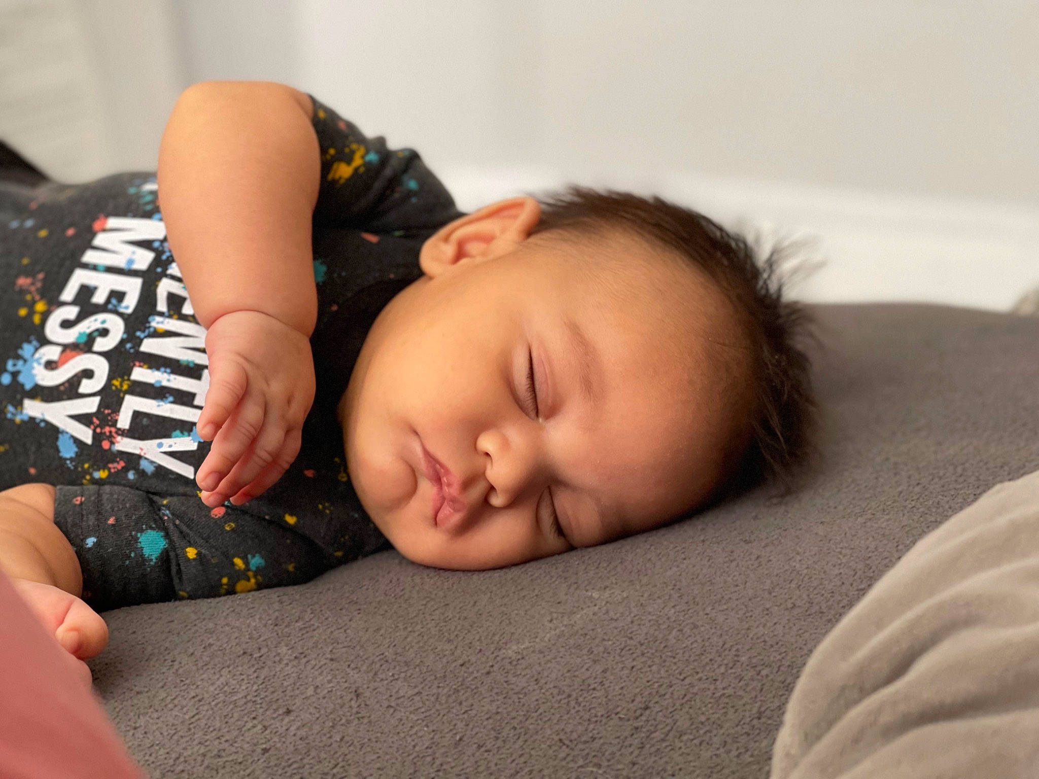 Ryker is registered to the contest to win money with this photo: baby, baby_toddler_clothing, bedtime, black_hair, cheek, child, comfort, eyelash, flash_photography, flooring, grass, linens, nap, person, portrait_photography, room, sitting, skin, sleeve, toddler