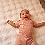 Florence is registered to the contest to win money with this photo: arms_outstretched, baby, blanket, child, cozy, cute, face, happy, human, indoor, infant, joyful, lying_down, pink_clothing, polka_dots, portrait, smiling, soft_texture, warm, young
