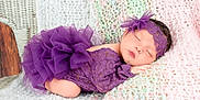 Carina is registered to the contest to win money with this photo: newborn, baby, sleeping, purple_lace, headband, knitted_blanket, pastel_colors, wicker_chair, soft_texture, portrait, infant, cute, peaceful, resting, closeup, delicate, indoors, fabric, tulle, face