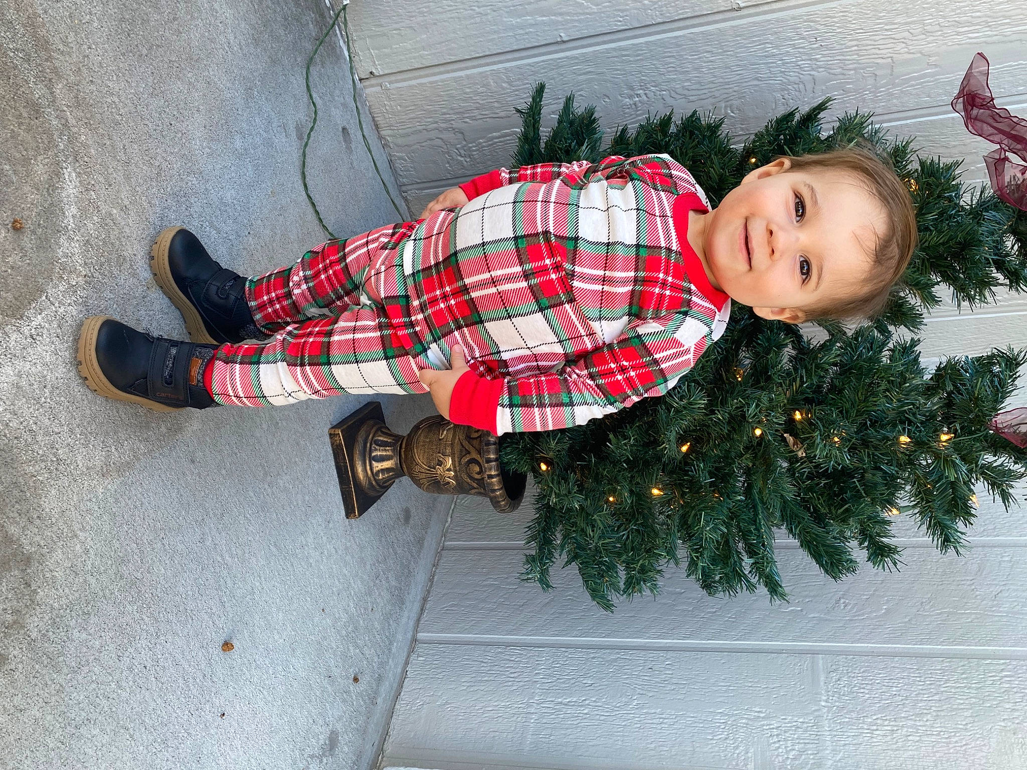 Braxton is registered to the contest to win money with this photo: christmas, christmas_decoration, christmas_ornament, christmas_tree, event, grass, head, holiday, holiday_ornament, joy, ornament, pattern, person, plaid, plant, sleeve, smile, tartan, toddler, tree