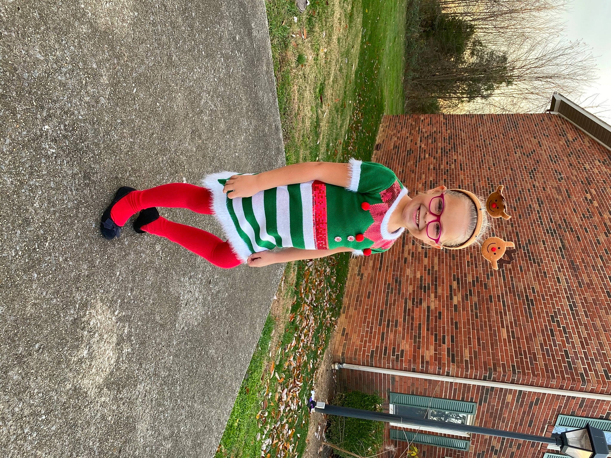 Harley is registered to the contest to win money with this photo: asphalt, brick, brickwork, carmine, fun, grass, human_leg, joy, leisure, person, plant, road, road_surface, shadow, shrub, sidewalk, soil, street, street_fashion, tree