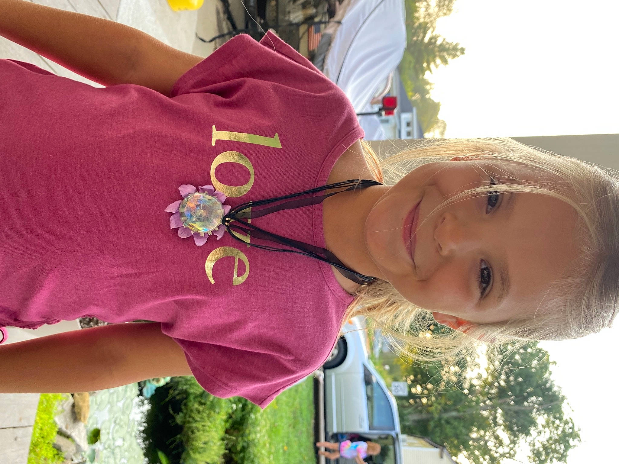 Harley joined the competition — help win amazing prizes! automotive_exterior, car, event, fun, gesture, grass, green, happy, joy, light, magenta, motor_vehicle, person, plant, sky, smile, toddler, tree, vehicle, vehicle_door