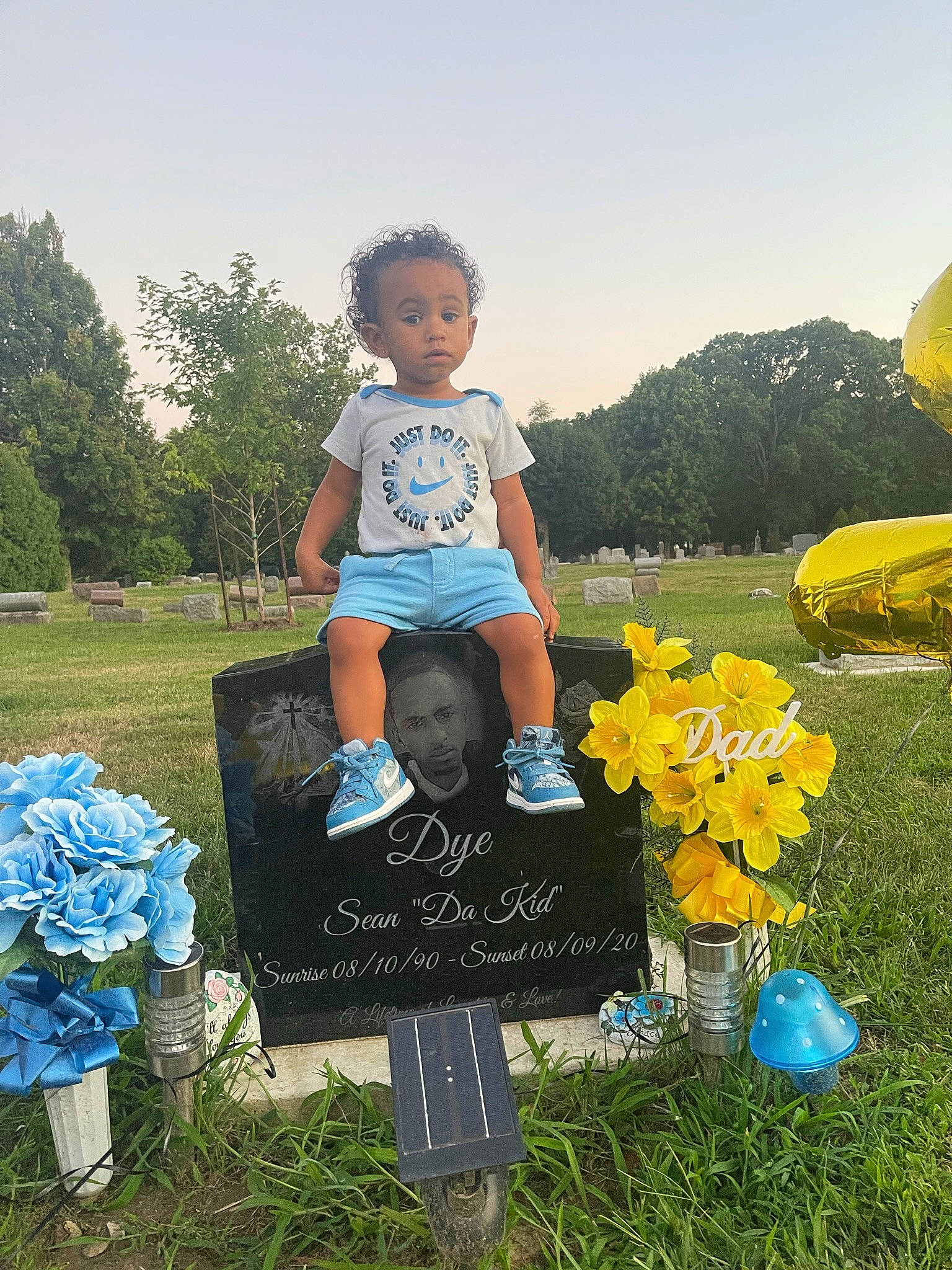 Sean is registered to the contest to win money with this photo: blue, flower, fun, grass, grassland, happy, landscape, lawn, leisure, meadow, nature, people_in_nature, person, plant, recreation, shorts, sky, summer, t_shirt, toddler