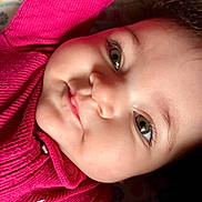 Izabella joined the competition — help win amazing prizes! baby, infant, child, face, eyes, cheeks, nose, lips, curly_hair, pink_sweater, clothing, close_up, portrait, lying_down, blanket, patterned_sheet, button, eyelashes, soft_skin, cute_expression