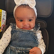 Ewenn a rejoint le concours — aidez-le/la à gagner de superbes lots ! baby, child, headband, bow, denim, overalls, car_seat, smile, face, infant, clothing, cute, portrait, happy, young_child, sitting, hand, indoors, seatbelt, person