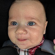 Emil participe au concours pour gagner de l'argent avec cette photo : baby, blue_eyes, face, plaid_clothing, car_seat, infant, close_up, child, smile, young, cute, person, skin, eyelashes, head, seatbelt, portrait, indoors, soft_lighting, expression
