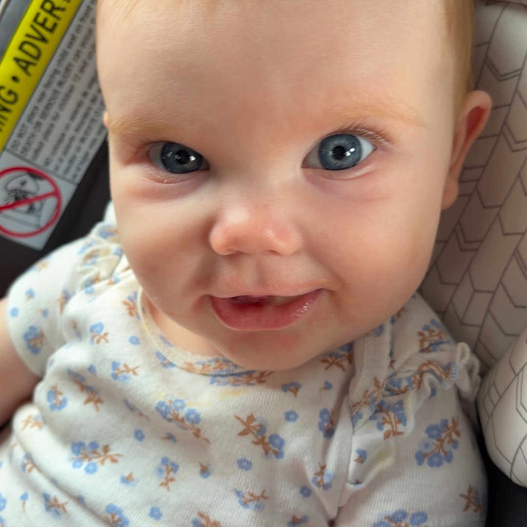 Havery Grace is registered to the contest to win money with this photo: baby, child, blue_eyes, smile, onesie, car_seat, infant, cute, face, skin, hair, clothing, sitting, indoors, portrait, person, closeup, happy, small_hands, seat