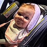 baby, infant, car_seat, child, bib, face, smile, seat_belt, head_support, pink, clothing, safety_warning, closeup, cute, portrait, child_seat, car_interior, soft_padding, baby_girl, young_child