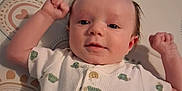 Scooter is registered to the contest to win money with this photo: baby, child, clothing, cute, face, happy, head, indoor, infant, lying_down, mattress, mohawk_hairstyle, onesie, patterned_background, portrait, raised_fists, skin, smiling, turtle_pattern, young_child