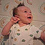 Scooter is registered to the contest to win money with this photo: baby, buttoned_shirt, child, cute, eyes, hand, happy, head, indoors, infant, lying_down, mattress, mouth, patterned_clothing, playmat, short_sleeve, skin, smile, spiky_hair, turtle_print