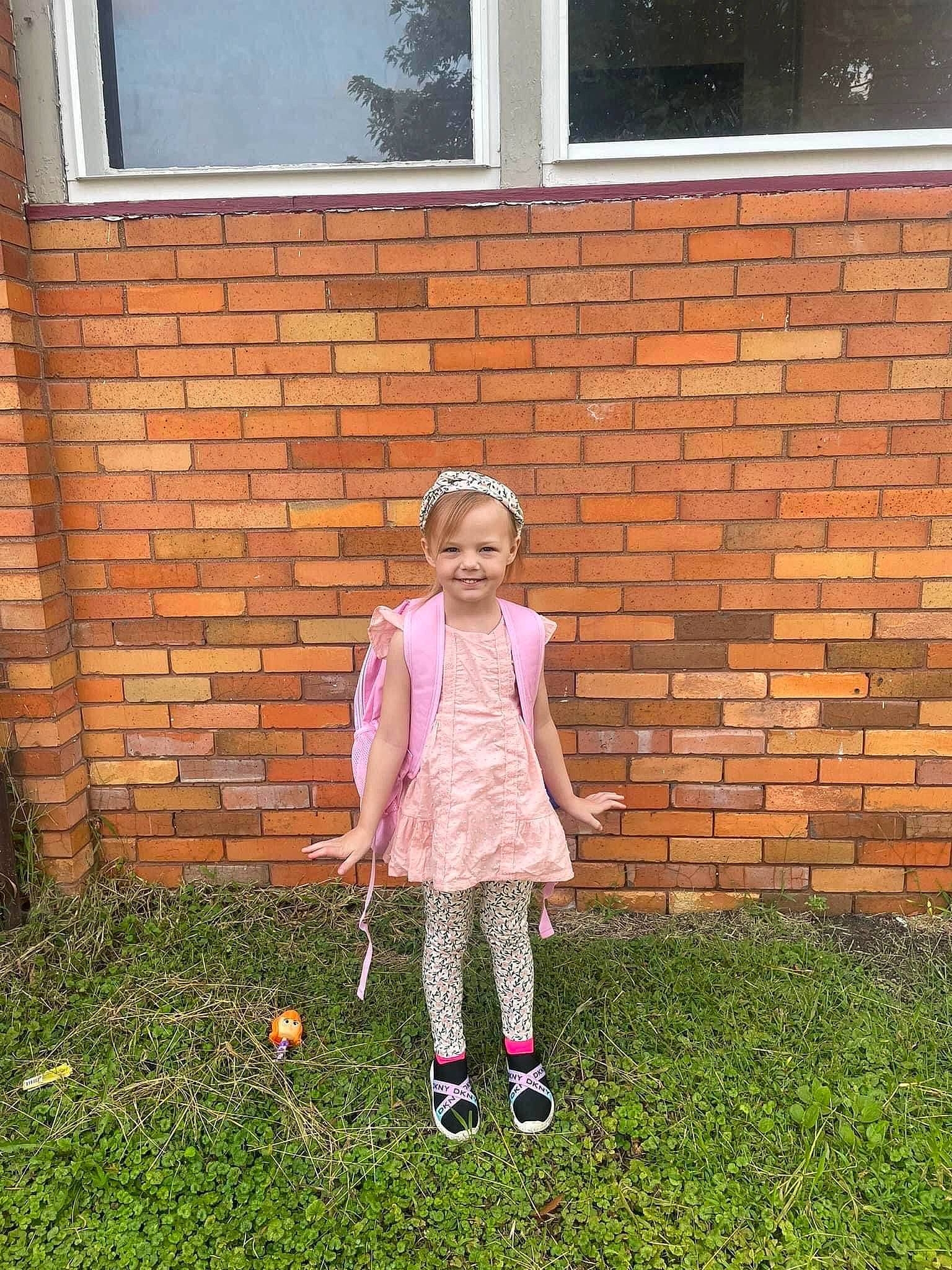Adelaide is registered to the contest to win money with this photo: brick, brickwork, child, door, fun, grass, grass_family, hat, house, joy, lawn, leaf, leisure, mammal, people_in_nature, person, recreation, smile, standing, toddler