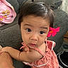 Kai Yumi is registered to the contest to win money with this photo: toddler, child, girl, face, flower, hair, pigtails, pink, dress, sleeveless, couch, arm, indoor, curious, person, baby, young_child, looking_up, holding, furniture