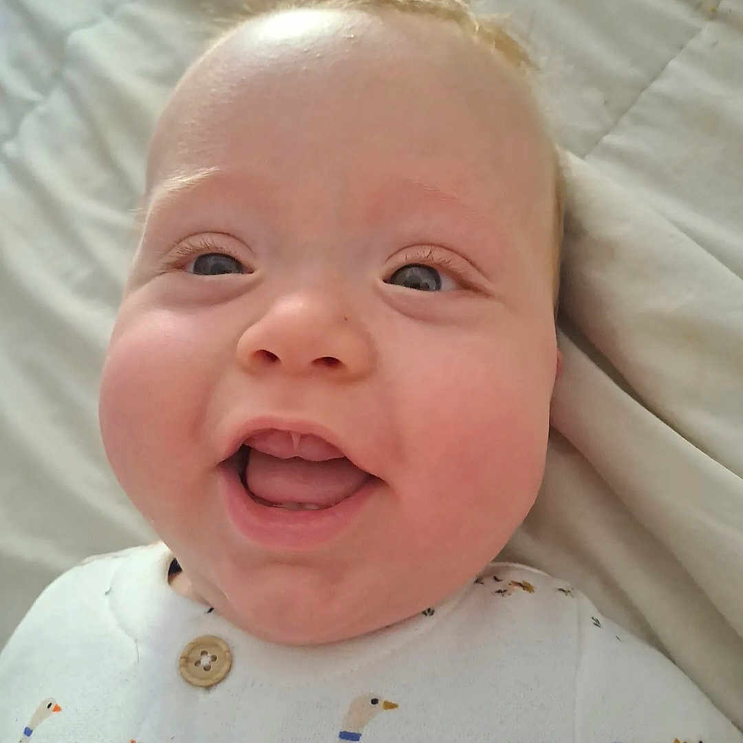 Ethan participe au concours pour gagner de l'argent avec cette photo : baby, child, closeup, clothing, cute, duck_print, eyes, face, happy, indoors, infant, lying_down, mouth_open, pattern, portrait, skin, smiling, soft_light, teeth, white_background