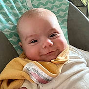 Benjamin joined the competition — help win amazing prizes! baby, infant, smile, face, bib, clothing, seat, pattern, green, white, yellow, cheeks, cute, child, portrait, indoors, happy, cushion, fabric, closeup