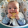 Benjamin joined the competition — help win amazing prizes! baby, cookie, high_chair, bib, smiling, happy, child, cute, indoor, clothing, face, hands, feeding, seat, pattern, animal_print, hot_air_balloon, playful, young_child, portrait