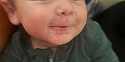 Kessler is registered to the contest to win money with this photo: arm, baby, child, closeup, clothing, cute, expression, face, head, human, indoor, infant, person, playful, portrait, skin, sleeve, smile, young, zipper