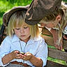 children, child, toddler, young_girl, park, outdoor, bench, pocket_watch, hat, flat_cap, blonde_hair, long_hair, white_shirt, vintage_clothing, plaid_skirt, sitting, leaning, portrait, sunlight, greenery