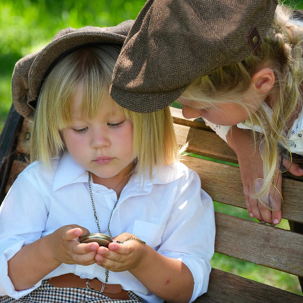 Milana Litvinchuk is registered to the contest to win money with this photo: children, child, toddler, young_girl, park, outdoor, bench, pocket_watch, hat, flat_cap, blonde_hair, long_hair, white_shirt, vintage_clothing, plaid_skirt, sitting, leaning, portrait, sunlight, greenery