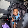 baby, car_seat, child, infant, blue_clothing, car_interior, leather_seat, seatbelt, purple_jacket, safety, portrait, young_child, cute, looking_at_camera, seat, car_backseat, daylight, window, child_safety, car_trip