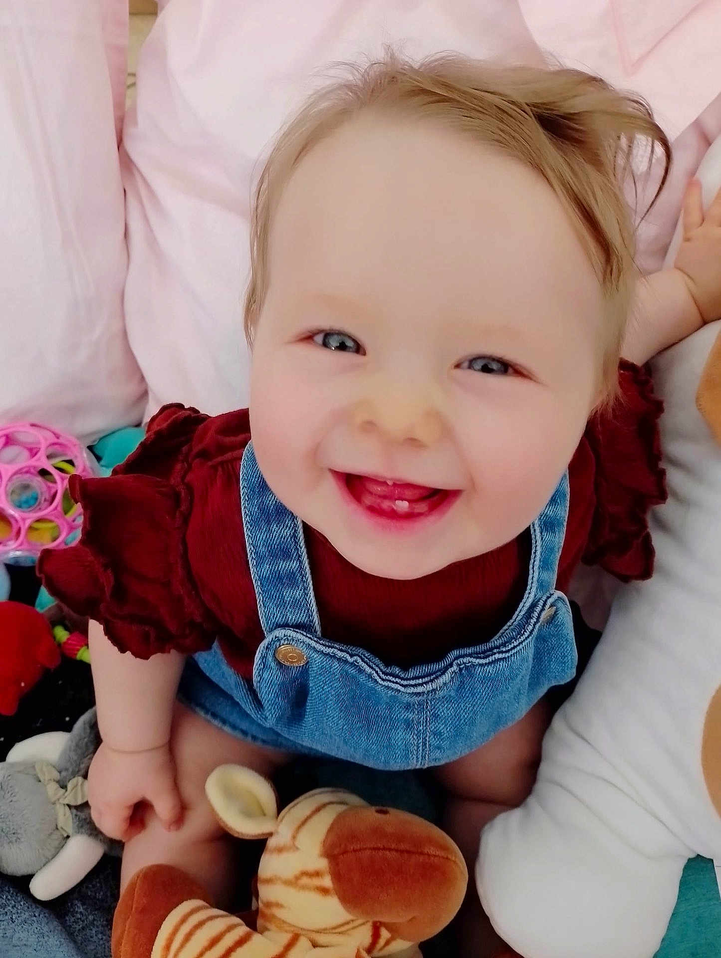Julia participe au concours pour gagner de l'argent avec cette photo : baby, smiling, child, denim_overalls, maroon_shirt, toys, stuffed_animals, indoor, happy, cute, face, blue_eyes, infant, playtime, soft_toys, cheerful, closeup, skin, person, sitting