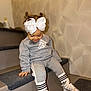 toddler, child, girl, sitting, stairs, white_bow, pigtails, grey_tracksuit, adidas, nike, socks, sneakers, indoor, carpet, smile, looking_down, cute, fashion, casual, happy