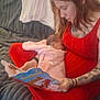 mother, infant, baby, breastfeeding, book, reading, red_dress, tattoo, sofa, cushion, blanket, cozy, living_room, carpet, hand, portrait, face, woman, child, parent