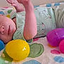 baby, infant, newborn, blanket, onesie, plastic_egg, easter_eggs, colorful, pastel, toy, face, eyes, hand, arm, lying_down, fabric, pattern, cute, bed, playful