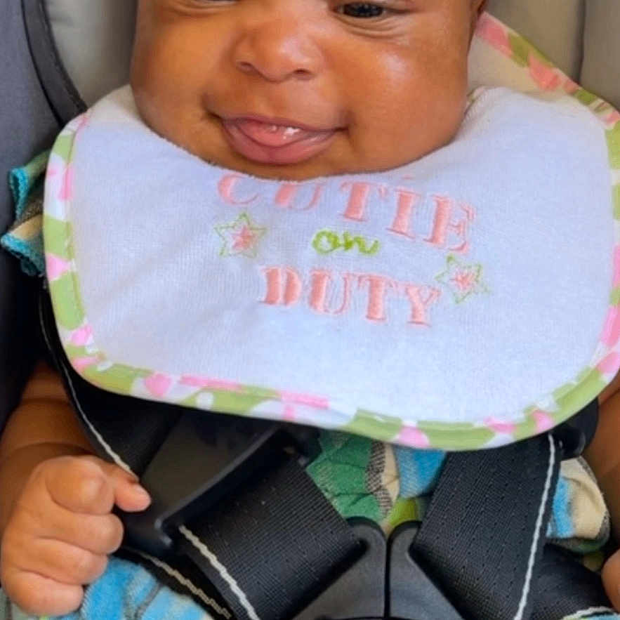 Kennedi is registered to the contest to win money with this photo: baby, child, headband, bib, car_seat, pacifier, smiling, tongue_out, clothing, safety_harness, cute, infant, happy, striped, colorful, seatbelt, portrait, indoors, person, young_child