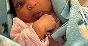 Kennedi is registered to the contest to win money with this photo: baby, infant, blanket, blue_blanket, floral_pattern, curious, wide_eyes, hand, soft_texture, indoors, cozy, cute, child, portrait, newborn, wrapped, warm, pink_clothing, closeup, face