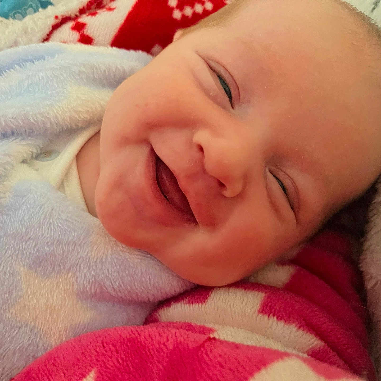 Rowan is registered to the contest to win money with this photo: baby, babylaughing, blanket, face, happy, head, laughing, newborn, person, photography, portrait, quilt, smile