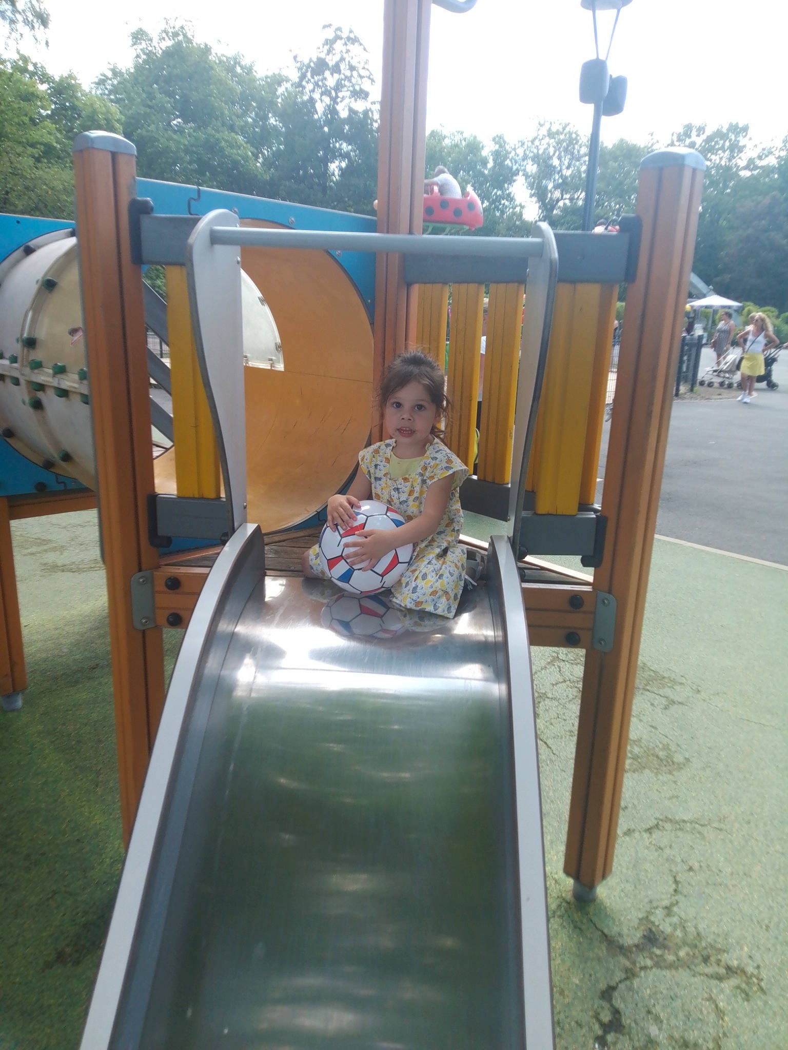 Jade participe au concours pour gagner de l'argent avec cette photo : baby_toddler_clothing, child, chute, city, fun, leisure, nonbuilding_structure, outdoor_play_equipment, person, play, playground, playground_slide, recreation, sitting, sky, t_shirt, toddler, tree, vacation, wood