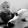 baby, dog, black_and_white, portrait, close_up, face, animal, child, pet, indoor, cute, friendship, relaxation, young_child, mammal, expression, sitting, cozy, companion, domestic_animal