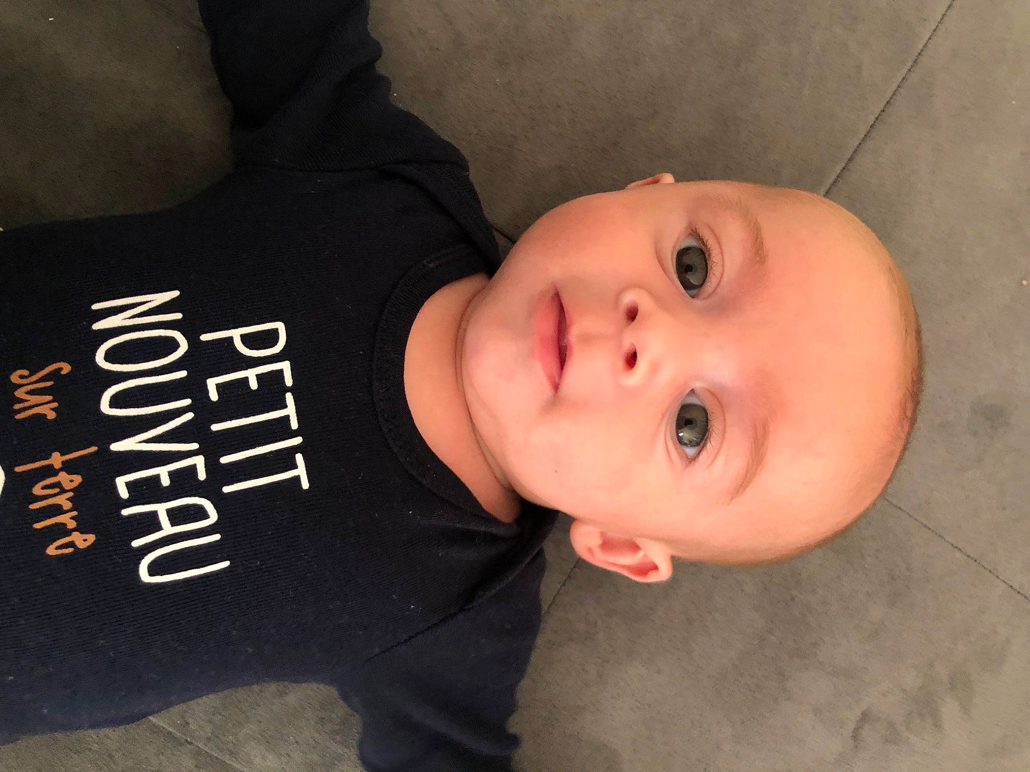 Léandro participe au concours pour gagner de l'argent avec cette photo : baby, baby_toddler_clothing, cheek, child, comfort, eye, eyelash, flooring, lip, nose, outerwear, person, sleeve, smile, t_shirt, toddler, wood
