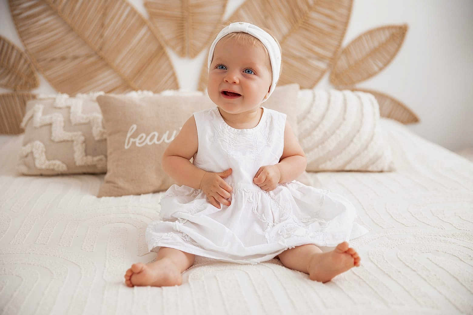 Ninon a rejoint le concours — aidez-le/la à gagner de superbes lots ! baby, bed, blue_eyes, child, cozy, cute, decor, happy, headband, homedecor, indoor, infant, leaf_pattern, pillows, portrait, sitting, smiling, soft_light, texture, white_dress