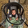 Noah is registered to the contest to win money with this photo: baby, infant, child, stroller, carriage, blanket, green_blanket, striped_shirt, harness, portrait, outdoor, park, autumn, leaves, tree, seated, wide_eyed, looking_at_camera, baby_gear, photography